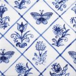 Diamond Shaped Tiles napkin with blue‑and‑white butterfly and floral tile motifs.