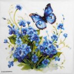 A close-up view of a Forget Me Not Lunch decoupage napkin featuring delicate blue floral patterns on a white background.