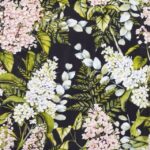 Quarter-fold view of the Soft Lilacs Black lunch decoupage napkin, displaying the full repeating floral pattern of lilac blossoms and foliage.