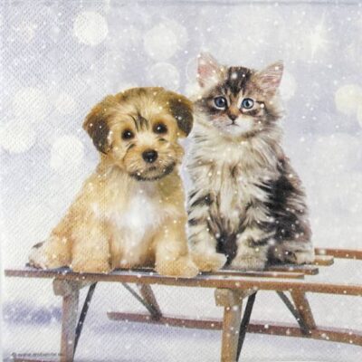 Quarter view of the Mimi and Bo paper napkin showing the puppy and kitten on a wooden sledge in a snowy winter scene.